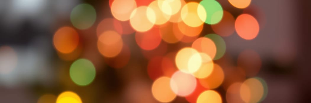 Glowing orbs of various colors fill the background, suggesting a vibrant holiday celebration. The soft focus adds warmth to the cozy indoor environment, perfect for gathering.