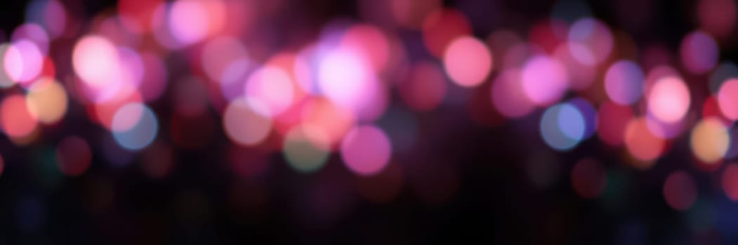 Soft, blurred lights in shades of pink, blue, and purple create a captivating atmosphere at a nighttime event. The vibrant colors enhance the festive mood of the celebration.