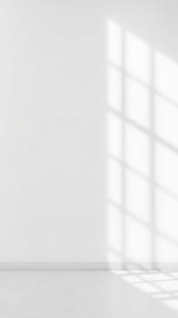Sunlight streams through a window, creating a grid of shadows on a smooth white wall. This modern setting features a clean, minimalistic design, emphasizing light and space.