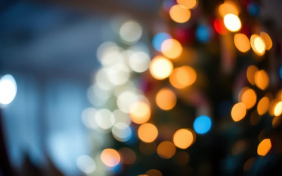 Softly blurred lights in various colors adorn a Christmas tree in a cozy indoor space, illuminating the room with a warm and festive glow, perfect for celebrating the holiday season.