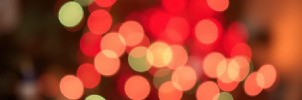 Bright red and green bokeh lights illuminate a warm indoor space, setting a joyful mood for a holiday gathering, inviting warmth and cheer.