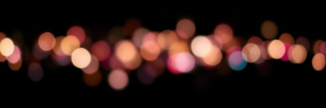 Vibrant blurred lights in various colors illuminate the backdrop, suggesting a lively atmosphere at a nighttime celebration or gathering.