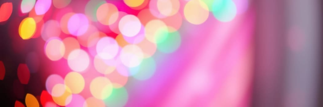 Vibrant bokeh lights in various colors create a festive mood during a nighttime event, enhancing the joyous ambiance for attendees to enjoy.