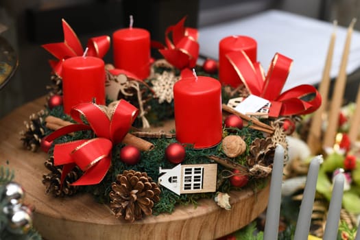 Wreath with red candle decorated with red balls, pine cones, cinnamon,walnuts.