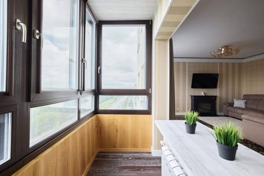 This sunroom features a stunning collection of plants and cozy furnishings in a stylish modern apartment