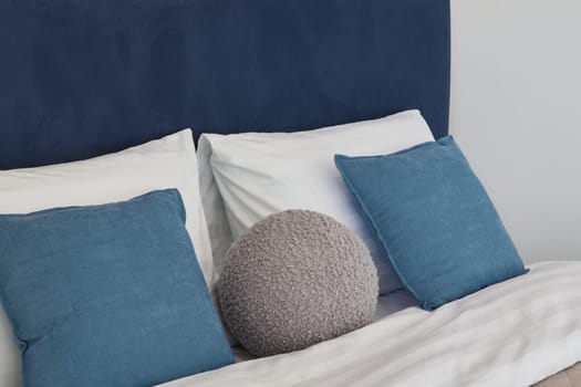 A modern bedroom setting showcasing an array of plush pillows and stylish decor that create a truly cozy atmosphere