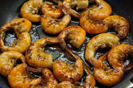 Golden pan-fried shrimp sizzling in a skillet, showcasing their rich, juicy texture and vibrant color. Ideal for use in cookbooks, restaurant menus, or gourmet advertisements
