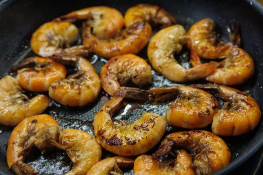 Golden pan-fried shrimp sizzling in a skillet, showcasing their rich, juicy texture and vibrant color. Ideal for use in cookbooks, restaurant menus, or gourmet advertisements