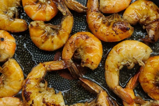 Golden pan-fried shrimp sizzling in a skillet, showcasing their rich, juicy texture and vibrant color. Ideal for use in cookbooks, restaurant menus, or gourmet advertisements