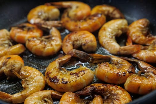 Golden pan-fried shrimp sizzling in a skillet, showcasing their rich, juicy texture and vibrant color. Ideal for use in cookbooks, restaurant menus, or gourmet advertisements