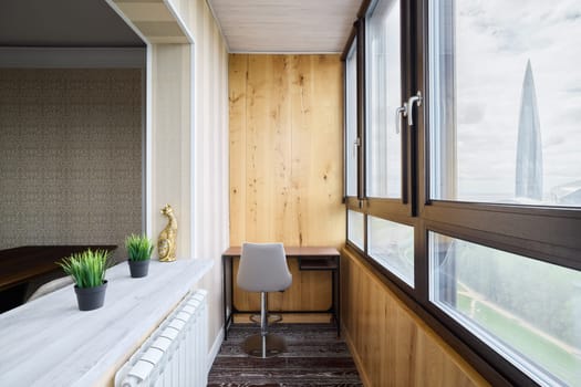 This is a stylish home office that features abundant natural light, minimalist design, and lovely wooden accents