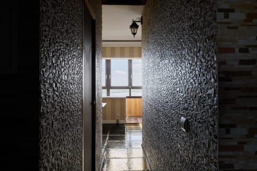 A serene and peaceful hallway that is beautifully illuminated by warm natural light, highlighting unique textured walls
