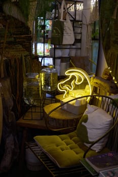 A delightful indoor corner space showcasing a bright neon light along with various rustic decor elements