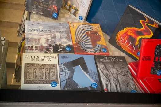 Cremona, Italy - November 27th 2024 Various books on art, architecture, history, and culture are displayed in a bookshop window, with a 50% discount sticker