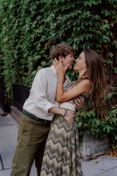 A couple lovingly shares a tender embrace in front of lush vibrant greenery, capturing intimate moments of deep love