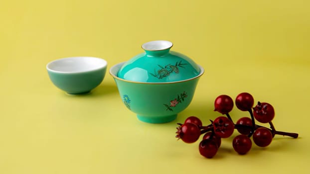 This is a stunning teaware display that showcases a lovely teal tea cup set against a vibrant, bright yellow background