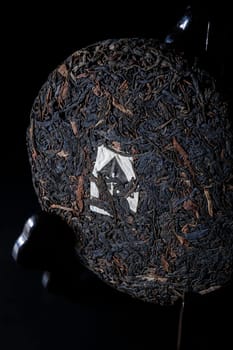 A detailed view of a beautifully compressed tea cake showcasing its unique texture and intricate design
