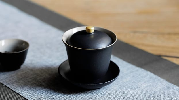 A trendy black tea cup set placed elegantly on a contemporary table, ideal for tea enthusiasts and home decor