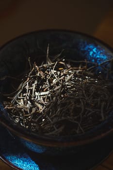 Closeup of dried twigs in a charming blue bowl, highlighting intricate textures and earthy elegance