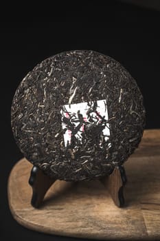 An exquisitely pressed tea cake featuring a unique, delightful texture, elegantly showcased on a rustic wooden stand