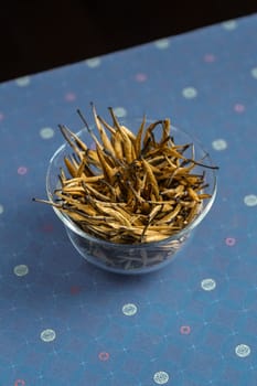 A bowl overflowing with a variety of dried herbs, showcasing their rich textures and vibrant colors