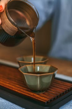 A serene moment of pouring aromatic tea into delicate cups, symbolizing tranquility and deeprooted tradition