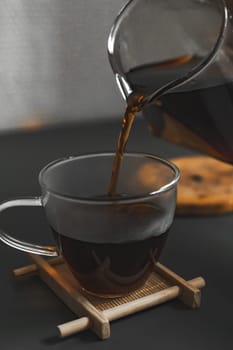 A tranquil moment encapsulating rich coffee being carefully poured into a beautifully stylish glass cup