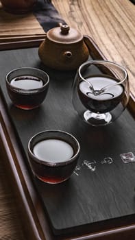 There is a stunning and beautifully arranged display of tea presented in traditional glassware on a wooden tray