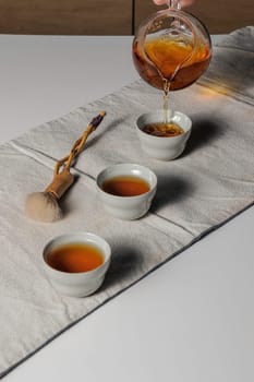 A serene and tranquil tea ceremony beautifully showcasing the art of pouring tea into elegant, delicate cups