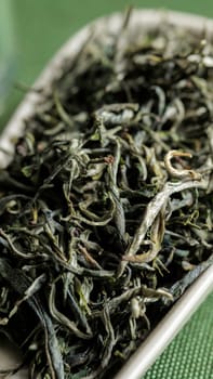 A stunning closeup of freshly harvested, premium quality green tea leaves displayed on a stylish dish