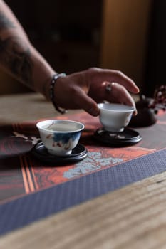 A tranquil moment during a tea ceremony that emphasizes artisanal teacups and the gentle, careful movements of hands