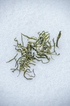 A closeup view of dried green tea leaves, which are perfectly prepared for steeping or various culinary uses