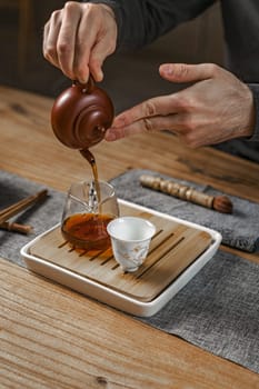 A peaceful and calming tea ceremony that beautifully showcases the graceful and skillful pouring of tea into cups