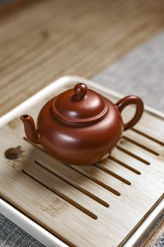 A beautifully crafted Chinese teapot elegantly resting on a rustic wooden tray, perfect for tea enthusiasts to enjoy
