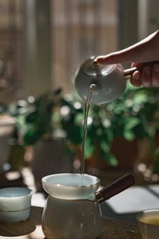 A serene and peaceful moment beautifully capturing the elegant art of tea pouring, surrounded by lush greenery