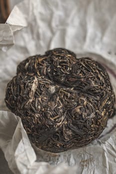 A closeup view of a beautifully compressed Puerh tea, showcasing its intricate leaf structure and unique texture