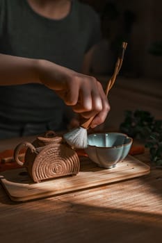 A serene moment of meticulously preparing tea, showcasing fine craftsmanship along with natural materials
