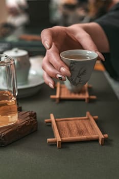 A calming and serene tea ceremony showcases delicate porcelain teacups paired elegantly with bamboo coasters