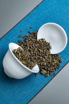 An aesthetically pleasing view showcasing loose leaf green tea gracefully spilling from an elegant bowl
