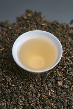 Oolong tea is elegantly displayed in a cup with loose leaves, creating a serene image for tea lovers