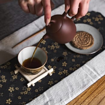 A serene moment captures tea pouring from a teapot, showcasing simplicity and elegance in every detail