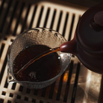 Immerse yourself in the peaceful and tranquil art of pouring tea, beautifully captured in soft and warm lighting