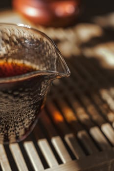 A stunning glass teapot elegantly displaying freshly brewed tea on a rustic wooden surface, glowing in soft sunlight