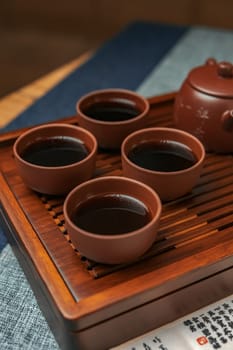 A beautifully serene display showcases a traditional tea setup that features four elegant teacups and a charming teapot