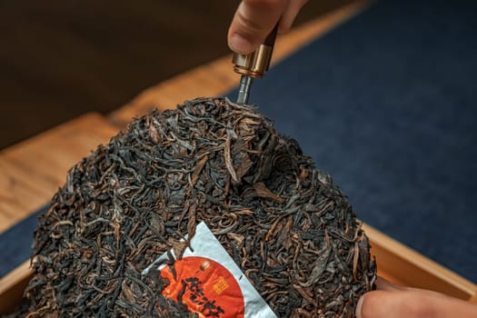 A detailed shot capturing the essence of breaking a tea cake, showcasing rich tea culture and preparation methods