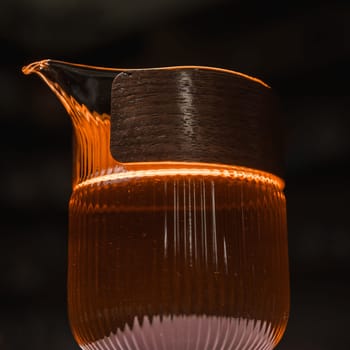 A beautifully stylish glass pitcher that is softly illuminated, highlighting its unique and modern design aesthetic
