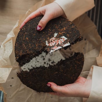 Hands skillfully breaking apart a beautiful tea cake, highlighting its unique texture and intricate design