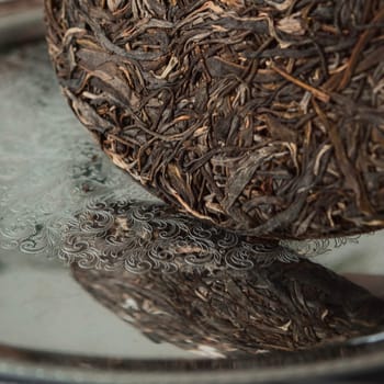An artistic depiction of a compressed tea ball, showcasing its rich texture and alluring reflection
