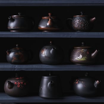 An elegantly curated display of black teapots that exemplify unique designs and exceptional fine craftsmanship