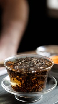 This image shows a closeup of freshly brewed green tea, emphasizing its rich color and natural leaves elegantly